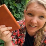 Debt-free homestead lifestyle woman with notebook and garden