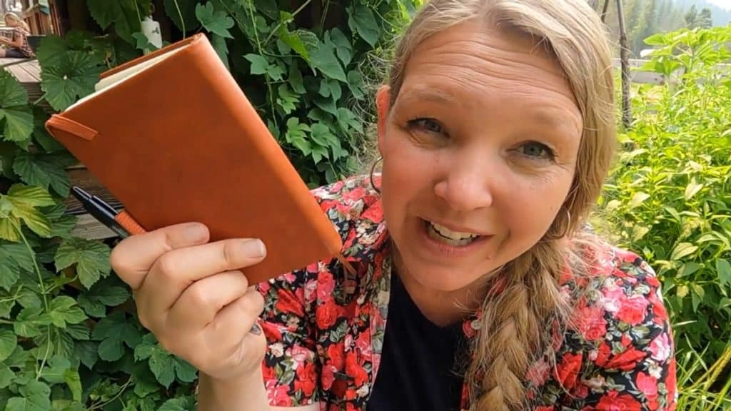 Debt-free homestead lifestyle woman with notebook and garden