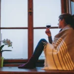 A woman looking out a farmhouse window in winter