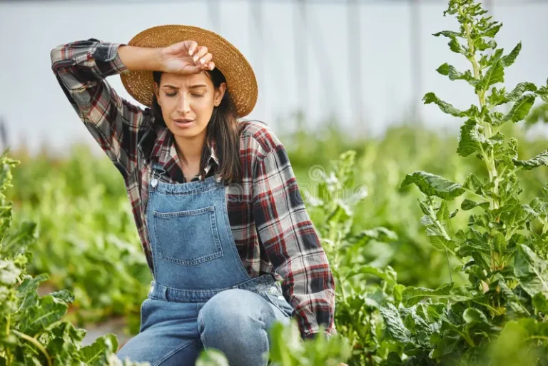 Tired woman resting in farm field with messy background